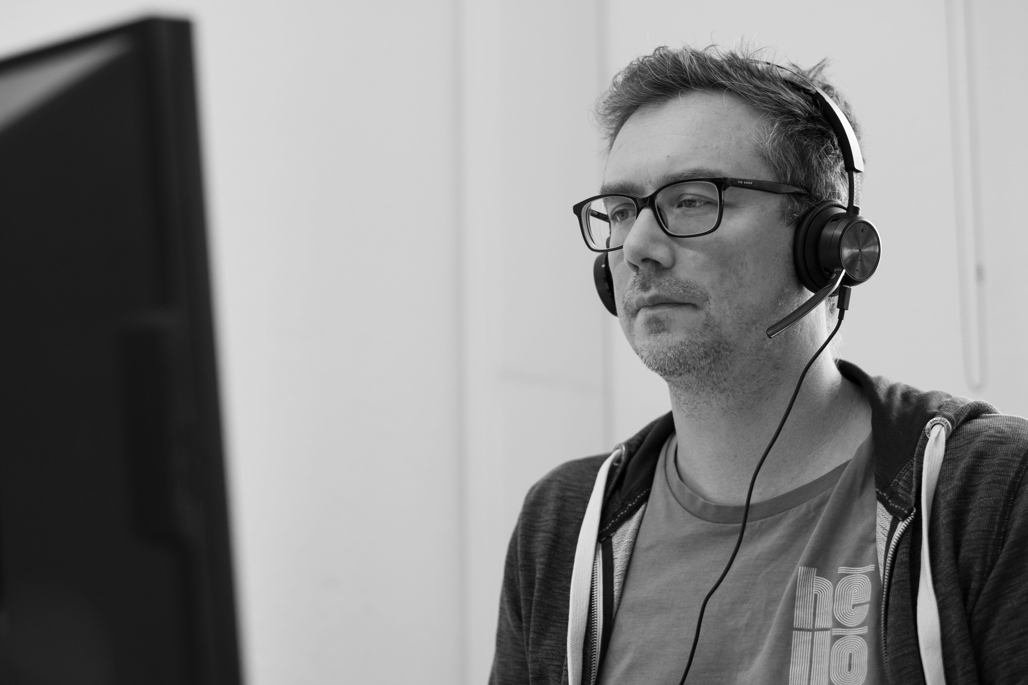 Kollege mit Headset vor dem Bildschirm