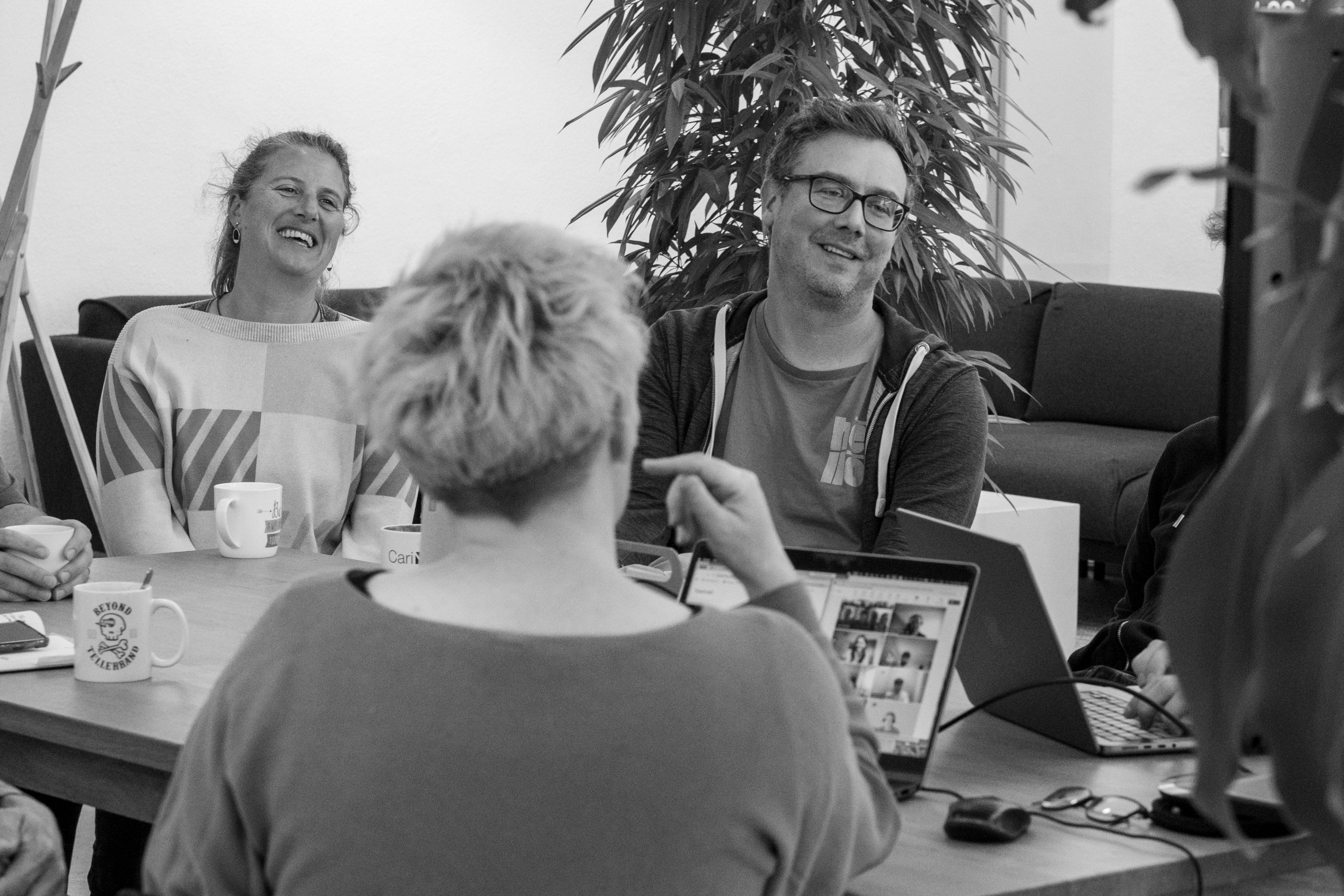 Kollegen lachen gemeinsam im Teammeeting
