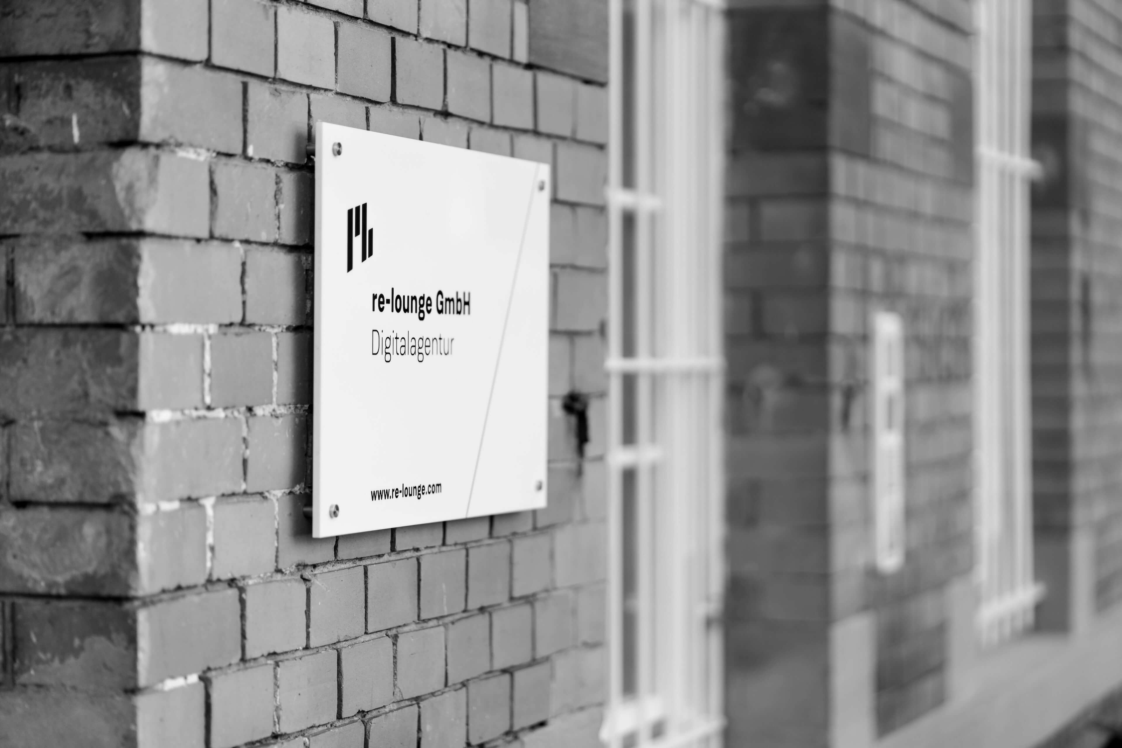 Firmenschild von re-lounge an der Fassade