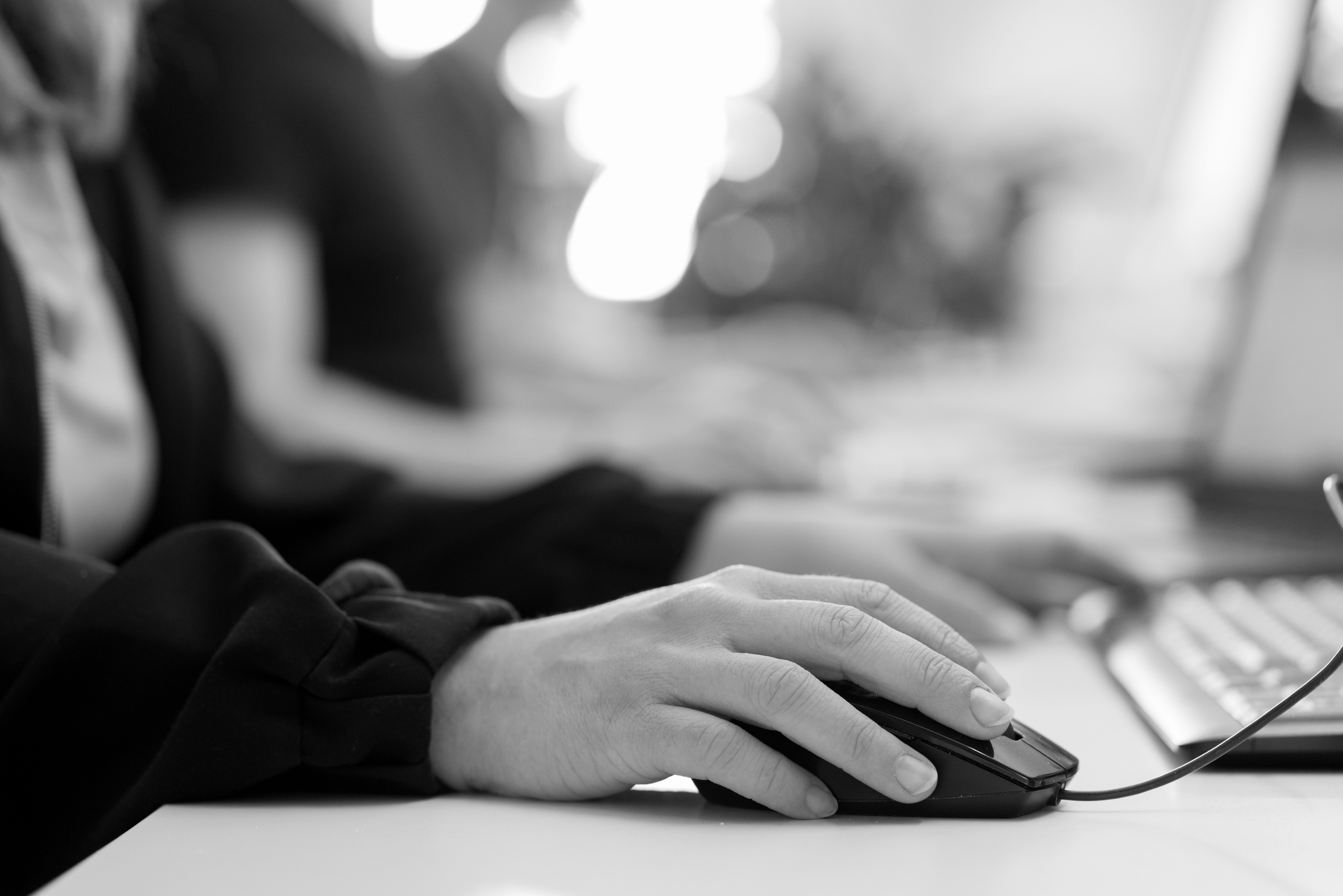 Hand an Computermaus während der Arbeit