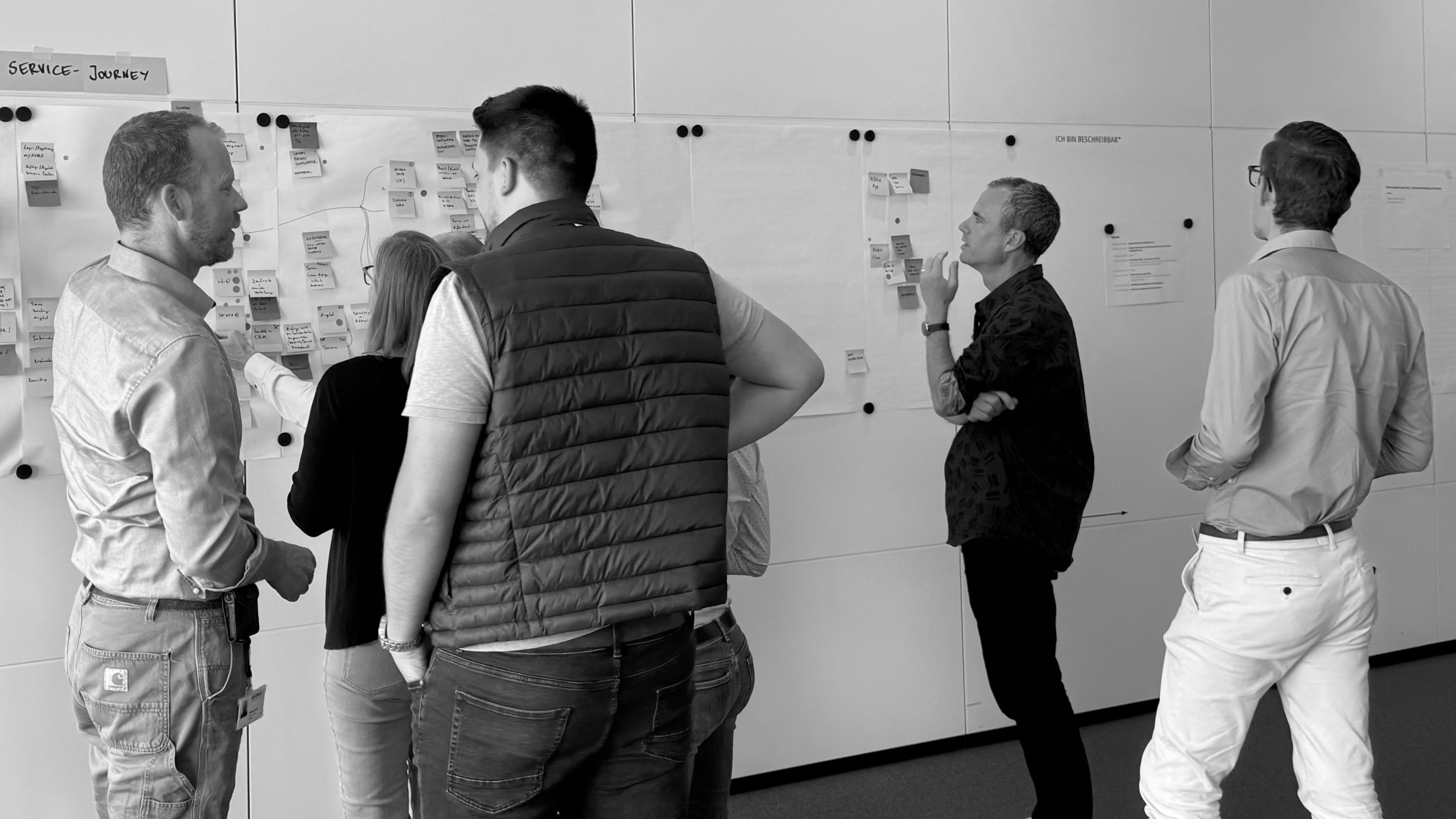 Workshopteilnehmer diskutieren vor Plakaten