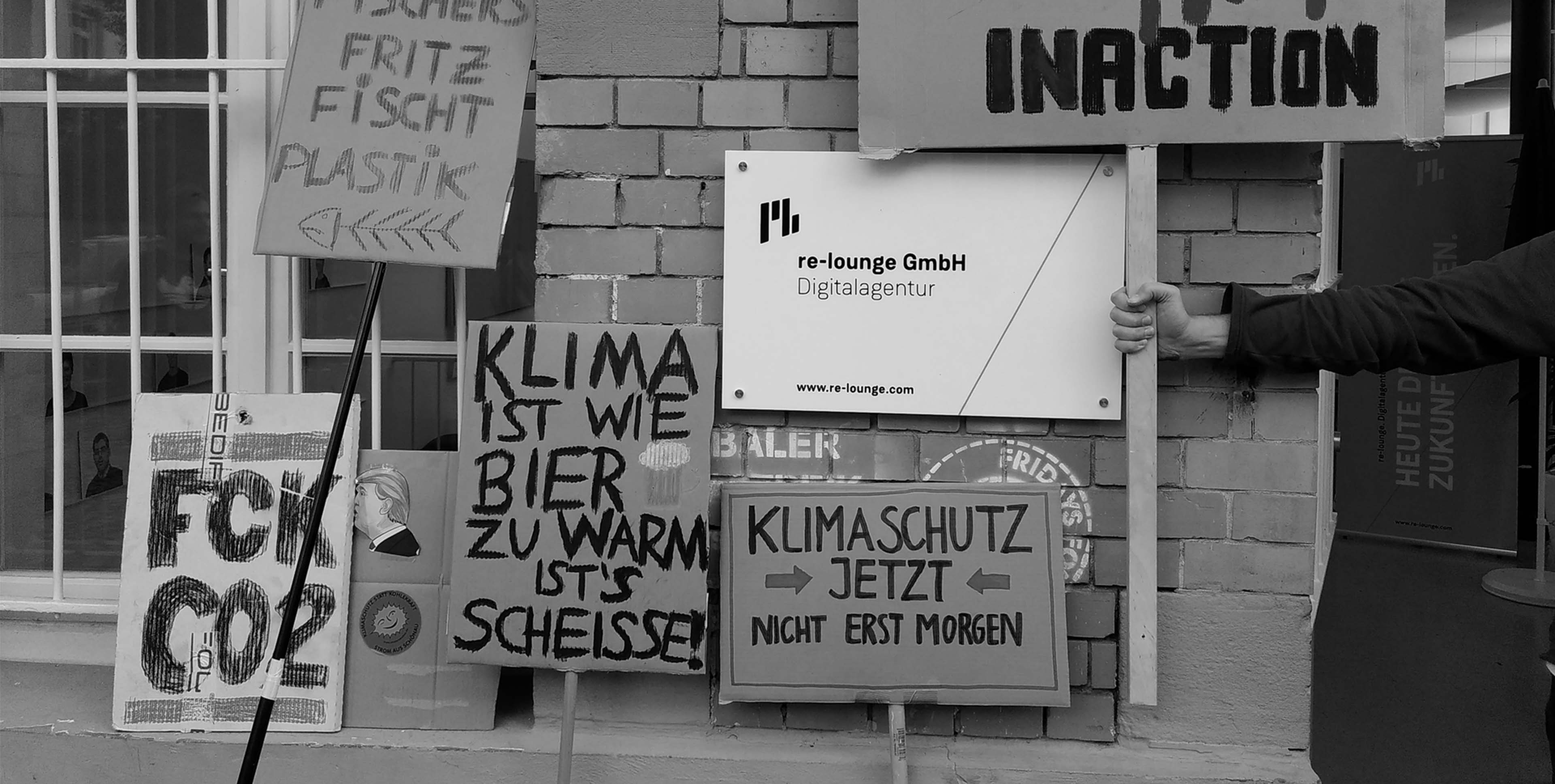An der Wand zu unserer Agentur lehnen mehrere unserer Klimademo Plakate mit folgenden Aufschriften: FUCKCO2, Fritz fischt Plastik, Klima ist wie Bier: zu warm ist’s scheiße und Klimaschutz JETZT nicht erst morgen.